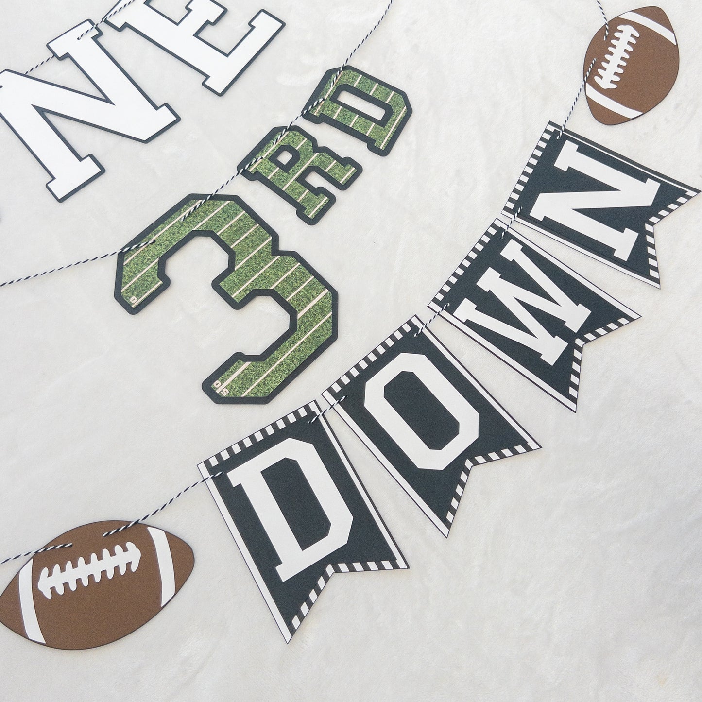 A custom-made banner with the text 'BENNETT'S 3RD DOWN' and football-themed decorations, including a football