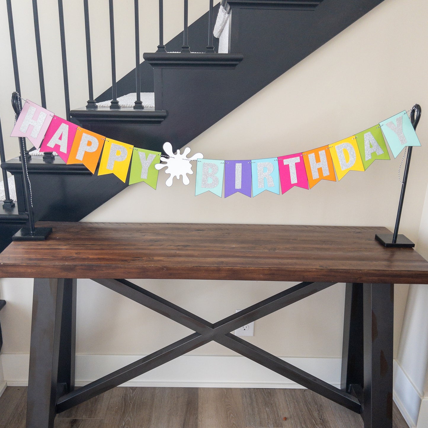 Features the words ‘happy birthday’ in bright and colorful paper. Includes the birthday girl’s name on paint brushes. The letters are made of kit sparkly silver. There are paint splatters on each side of the name.