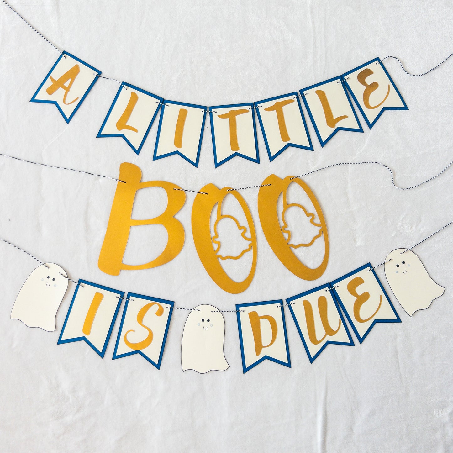 A decorative banner with the text 'A LITTLE BOO IS DUE' in a Halloween-themed design, featuring ghost shapes and gold letters on a string.