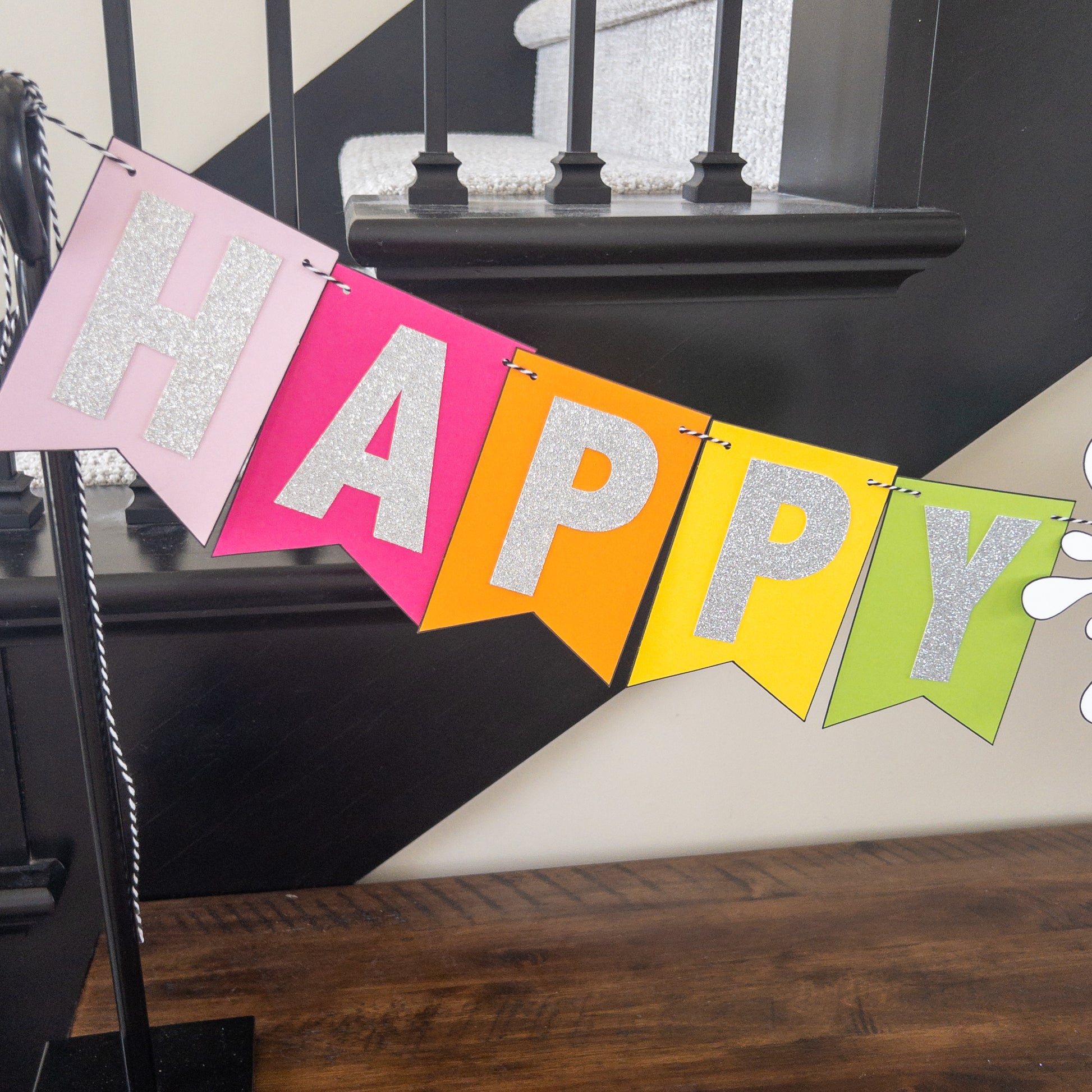 Features the words ‘happy birthday’ in bright and colorful paper. Includes the birthday girl’s name on paint brushes. The letters are made of kit sparkly silver. There are paint splatters on each side of the name.