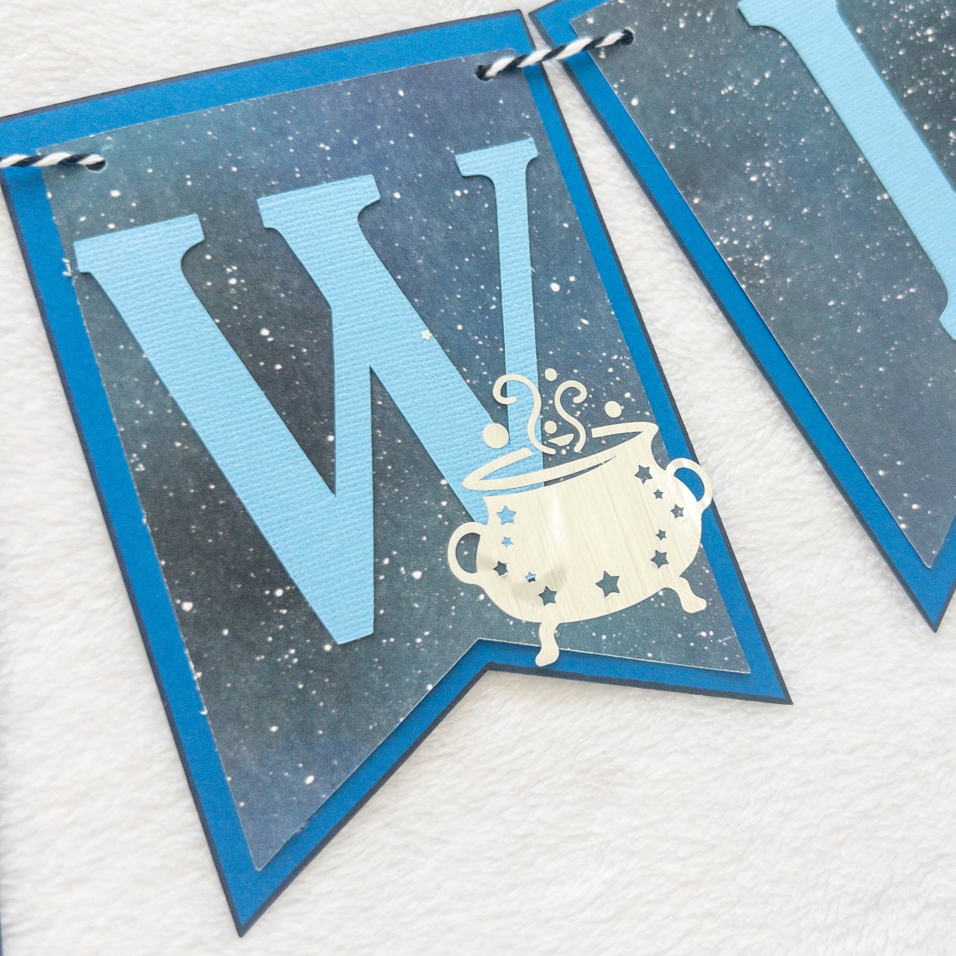 A banner with blue paper letters spelling 'A BABY IS BREWING' with stars and a blue border