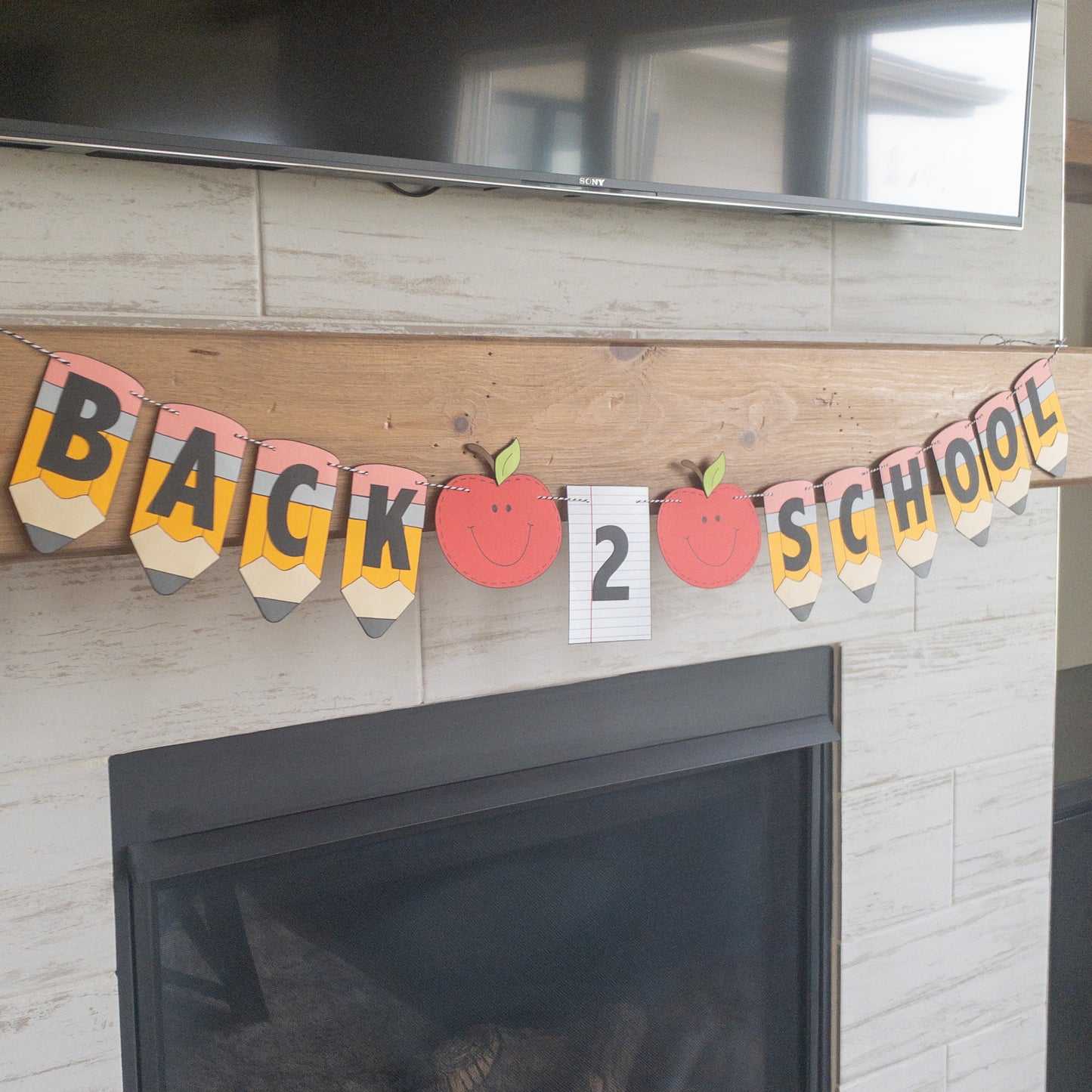 A 'Back to School' themed banner made of paper letters spelling out the phrase, with decorative elements such as apples and pencils, and a piece of lined paper.