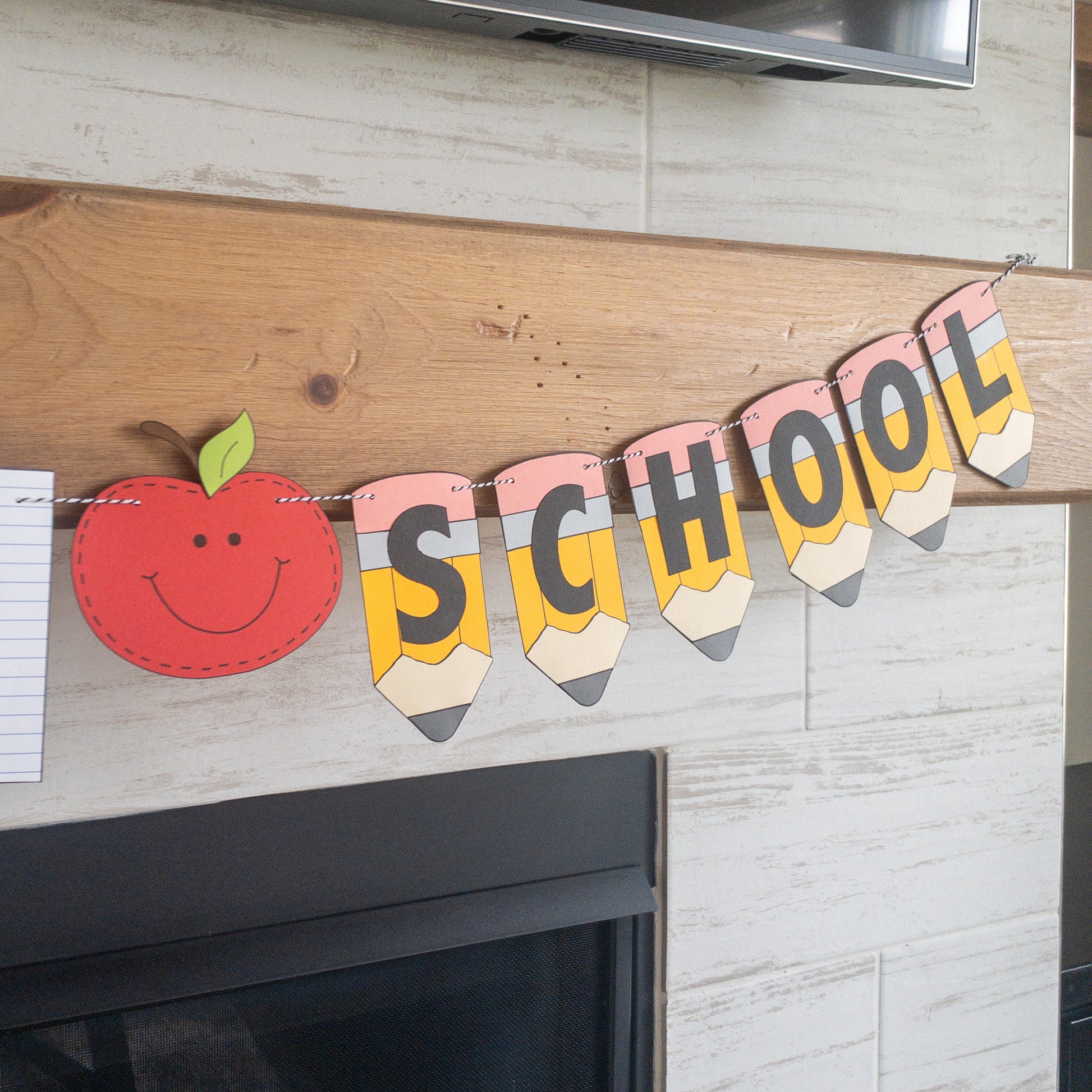 A 'Back to School' themed banner made of paper letters spelling out the phrase, with decorative elements such as apples and pencils, and a piece of lined paper.