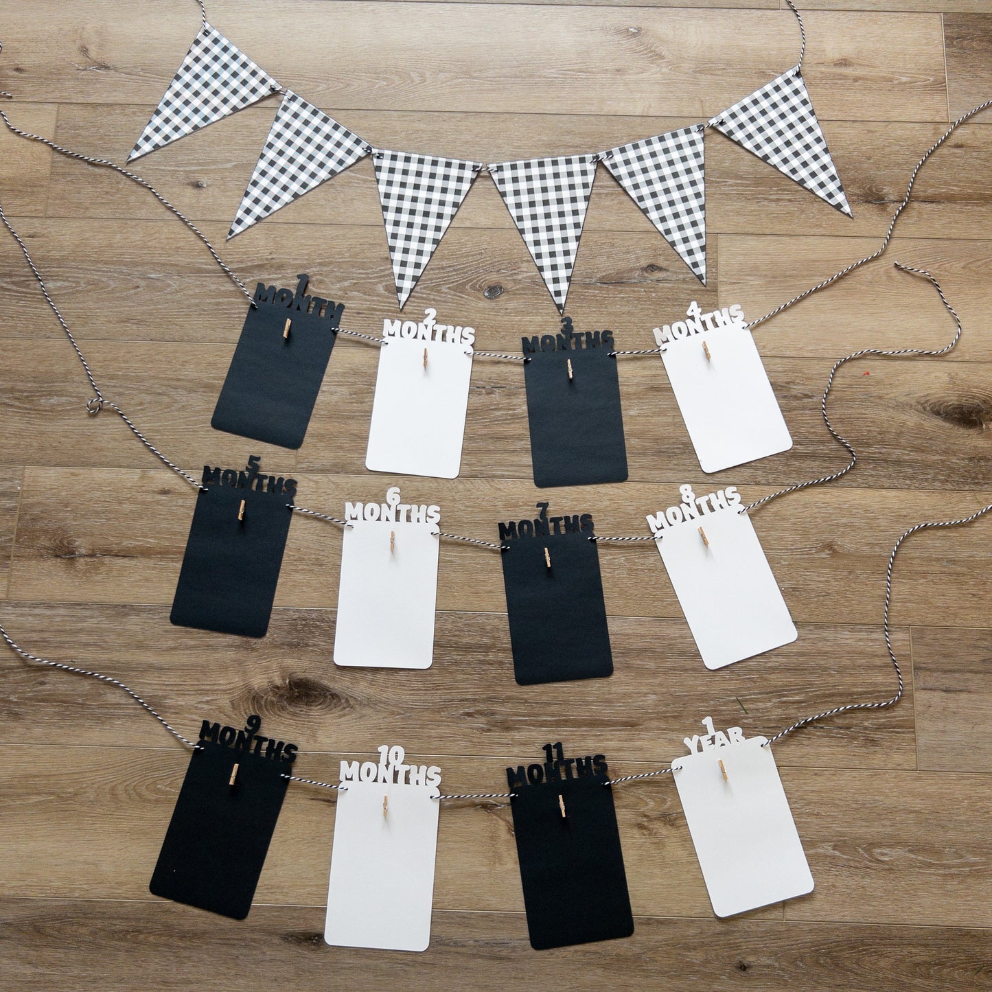 A colorful banner made of paper in black and white, each with a photo clip attached to it, strung together with a string.