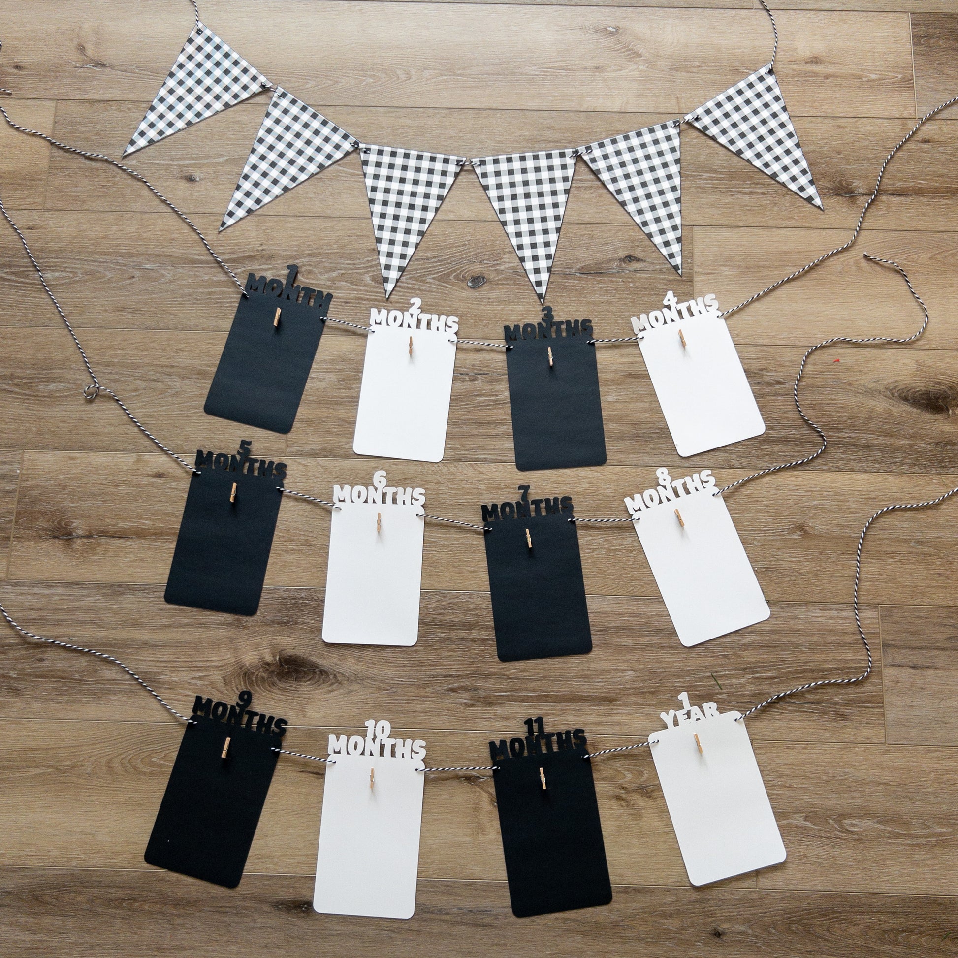A colorful banner made of paper in black and white, each with a photo clip attached to it, strung together with a string.