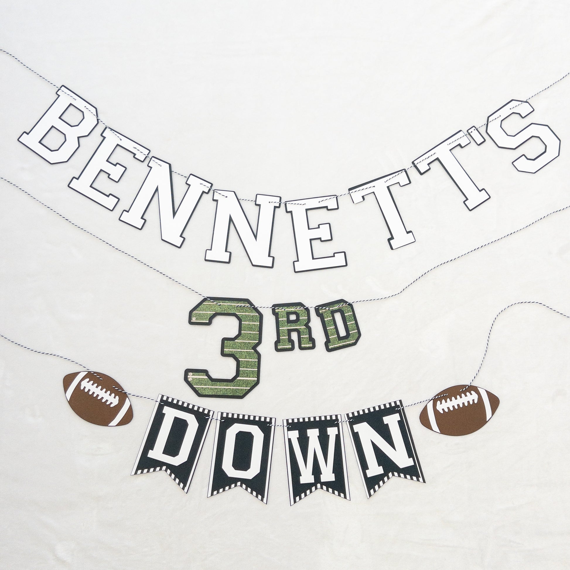 A custom-made banner with the text 'BENNETT'S 3RD DOWN' and football-themed decorations, including a football
