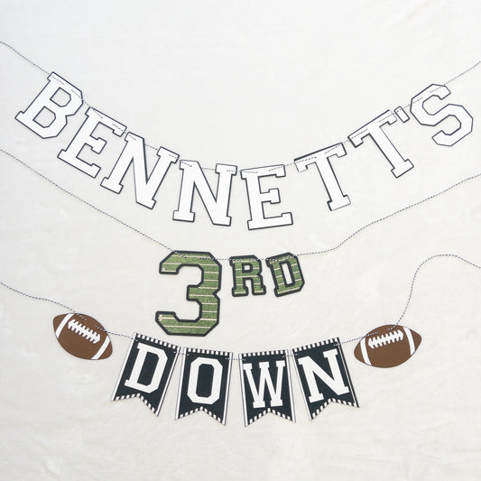 A custom-made banner with the text 'BENNETT'S 3RD DOWN' and football-themed decorations, including a football