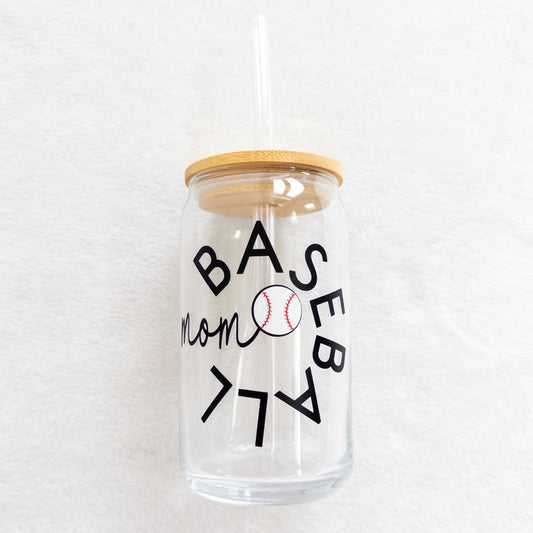 A clear glass cup with a 'Baseball Mom' text and a baseball symbol printed on it, including a straw and a lid.